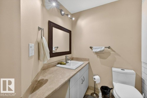 This restroom features a vanity with a countertop, a sink with a faucet, and a mirror above it - 16107 92 Street, Edmonton, AB - Indoor Photo Showing Bathroom