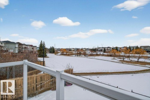 Enjoy expansive views of the snow-covered grounds and surrounding residential area from the property's glass-paneled railing - 16107 92 Street, Edmonton, AB - Outdoor With View