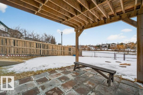 The property features a patio area with flagstone paving and an exposed wooden beam ceiling - 16107 92 Street, Edmonton, AB - Outdoor With Deck Patio Veranda