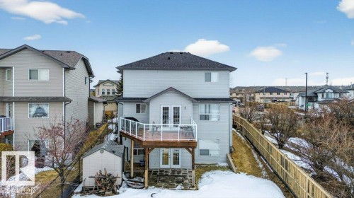The property features a multi-level deck with glass panel railings, a ground-level patio, and a utility shed - 16107 92 Street, Edmonton, AB - Outdoor With Deck Patio Veranda