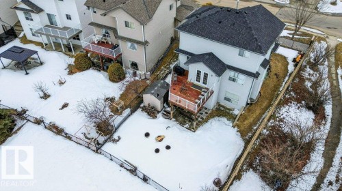 This property features a two-story residence with a dark shingled roof, a wooden deck, and a detached shed in the backyard - 16107 92 Street, Edmonton, AB - Outdoor