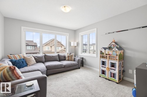 Large Bonus Room Space on the Upper Level featuring Large North West Facing Windows. Great for Movie Nights, Play Time, or add a door and create a 4th Upstairs Bedroom! - 20023 17A Avenue, Edmonton, AB - Indoor Photo Showing Living Room