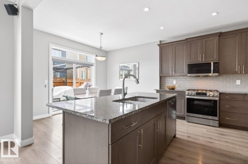 Stylish Kitchen featuring Quartz Counters, Stainless Steel Appliances (Bosh Dishwasher, Whirlpool Refrigerator, LG GAS Stove, LG Microwave Hood Fan), Subway Tile Backsplash, and plenty of Counter and Cabinet Space. - 20023 17A Avenue, Edmonton, AB - Indoor Photo Showing Kitchen With Double Sink With Upgraded Kitchen