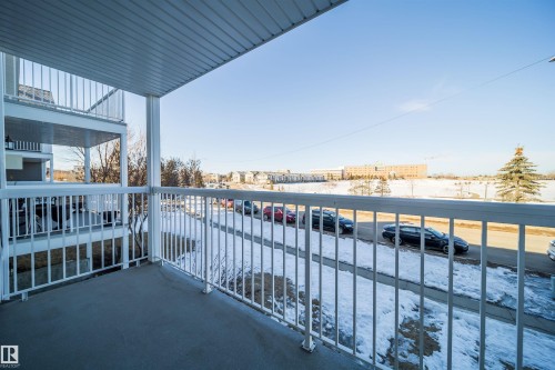 Outdoor balcony with white metal railings and a textured concrete floor - 213 5065 31 Avenue, Edmonton, AB - Outdoor With Body Of Water With Exterior
