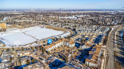 Expansive aerial perspective showcasing a residential development with multiple buildings featuring brown-toned roofs - 213 5065 31 Avenue, Edmonton, AB - Outdoor With View