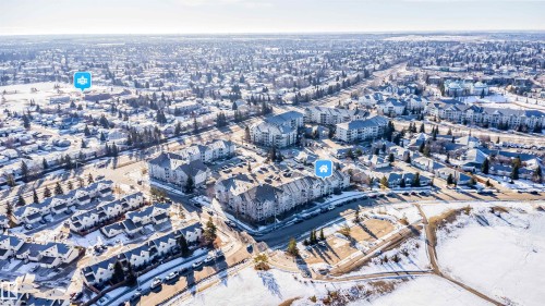Aerial perspective showcasing a residential area with diverse property types, including multi-story buildings and townhome-style residences - 213 5065 31 Avenue, Edmonton, AB - Outdoor With View