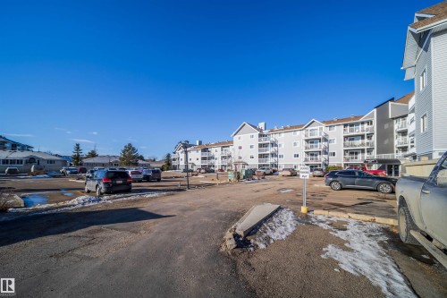 Multi-level building exterior featuring light grey siding, white trim, and numerous private balconies - 213 5065 31 Avenue, Edmonton, AB - Outdoor