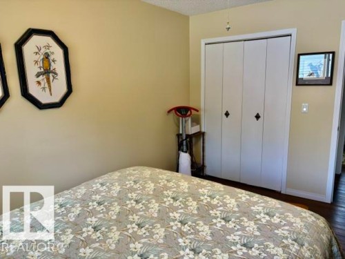 Bi-fold closet doors with diamond-shaped hardware - 4805 53Ave, Willingdon, AB - Indoor Photo Showing Bedroom