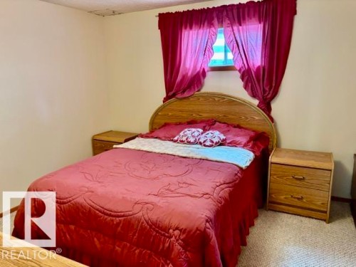 Bedroom featuring neutral wall paint, carpet flooring, and a window with a valance - 4805 53Ave, Willingdon, AB - Indoor Photo Showing Bedroom