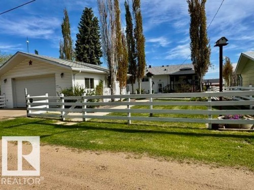 White split-rail fencing enclosing a manicured lawn - 4805 53Ave, Willingdon, AB - Outdoor With Deck Patio Veranda