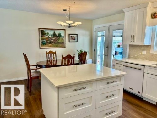 Kitchen island featuring light-toned countertops and white cabinetry with brushed nickel hardware - 4805 53Ave, Willingdon, AB - Indoor