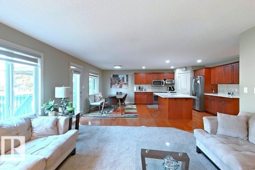 Open-concept living space featuring wood-finish flooring in the kitchen and dining areas - 1206 Mckinney Court, Edmonton, AB - Indoor Photo Showing Living Room