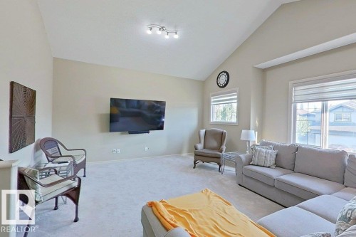 Spacious living area featuring a vaulted ceiling and light-colored carpeting - 1206 Mckinney Court, Edmonton, AB - Indoor Photo Showing Living Room
