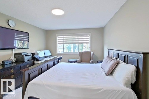 Spacious room featuring neutral wall tones, a large window with horizontal blinds, and a built-in overhead light fixture - 1206 Mckinney Court, Edmonton, AB - Indoor Photo Showing Bedroom