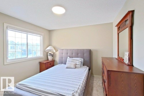 Bedroom featuring light neutral wall paint, a large window with white framing, and wall-to-wall carpeting - 1206 Mckinney Court, Edmonton, AB - Indoor Photo Showing Bedroom