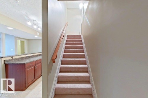 Carpeted staircase with wooden handrail - 1206 Mckinney Court, Edmonton, AB - Indoor Photo Showing Other Room
