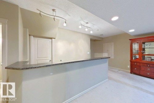 Entertainment bar with a stone-look countertop, recessed lighting, track lighting, and soft carpeting - 1206 Mckinney Court, Edmonton, AB - Indoor Photo Showing Other Room