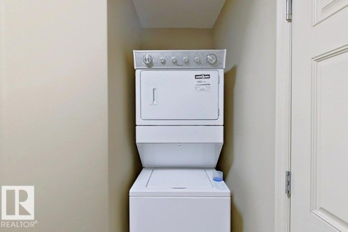 Dedicated laundry area featuring a white stacked washer and dryer unit, providing efficient use of space - 1206 Mckinney Court, Edmonton, AB - Indoor Photo Showing Laundry Room