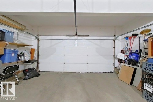 Concrete flooring with a white paneled garage door and an overhead track system - 1206 Mckinney Court, Edmonton, AB - Indoor Photo Showing Garage