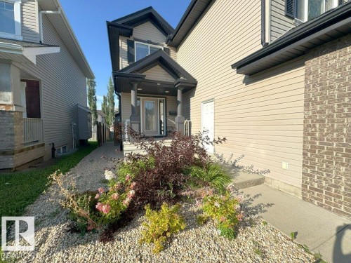 Property exterior featuring a covered front entry with dark columns and a glass-paneled door - 1206 Mckinney Court, Edmonton, AB - Outdoor