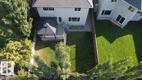 Expansive backyard featuring a covered deck, gazebo structure, concrete patio, and a grass lawn with mature trees - 1206 Mckinney Court, Edmonton, AB - Outdoor
