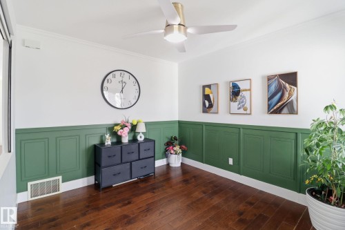 This interior space features hardwood floors, white crown molding, and a ceiling fan with integrated lighting - 3243 26 Street, Edmonton, AB - Indoor Photo Showing Other Room