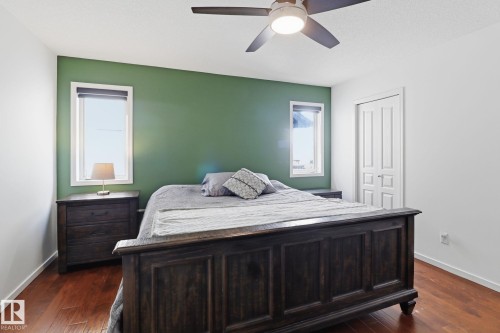 Bedroom featuring hardwood flooring, a ceiling fan with integrated lighting, and white trim around windows and doors - 3243 26 Street, Edmonton, AB - Indoor Photo Showing Bedroom