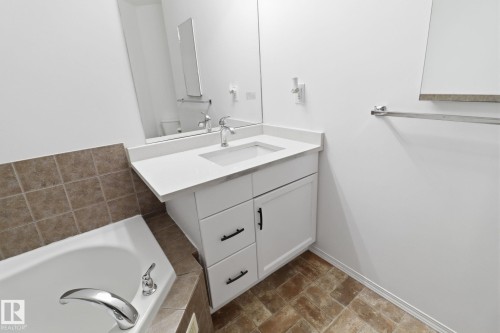Bathroom featuring a white vanity with a rectangular sink, a polished chrome faucet, and a mirror - 3243 26 Street, Edmonton, AB - Indoor Photo Showing Bathroom