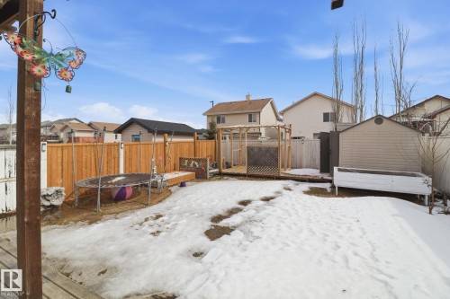 The property features a fenced backyard with a wooden deck, a storage shed, and a raised planter box - 3243 26 Street, Edmonton, AB - Outdoor
