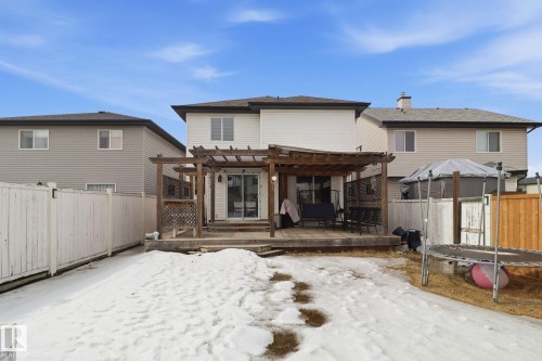The property features a wooden deck with a pergola, accessible via sliding glass doors - 3243 26 Street, Edmonton, AB - Outdoor