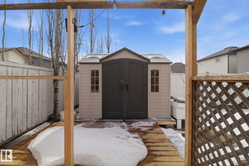 The property features an outdoor shed with dual doors and two windows, set on a wooden deck - 3243 26 Street, Edmonton, AB - Outdoor With Exterior