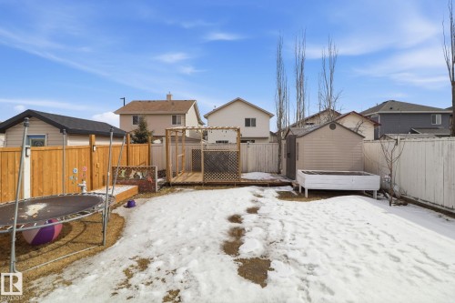 The property includes a spacious backyard with a wooden fence, a garden shed, and a wooden deck area - 3243 26 Street, Edmonton, AB - Outdoor