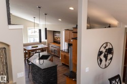 Kitchen island featuring a black stone countertop, integrated sink, and stacked stone base - 