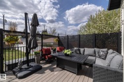 Expansive deck with wood-finish flooring, featuring decorative black privacy screens, and black metal railings - 