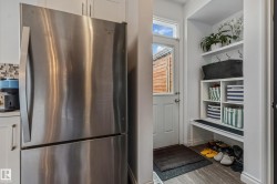 Entryway with built-in storage featuring a bench, shelving, and wall hooks - 