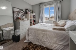 Carpeted bedroom featuring a window with natural light, neutral wall paint, and a built-in ceiling light fixture - 