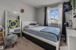 Carpeted room featuring a window with white trim, a built-in shelving unit, and neutral wall paint - 