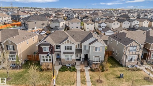 Modern duplex featuring diverse exterior finishes including stone accents, siding, and gabled roofs - 8131 Chappelle Way, Edmonton, AB - Outdoor With Facade
