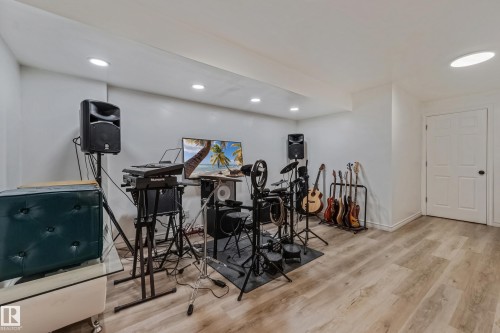 Finished room featuring light wood-finish flooring, recessed lighting, and a white paneled door - 8131 Chappelle Way, Edmonton, AB - Indoor