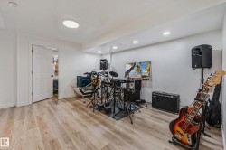 Spacious room featuring wood-finish flooring, recessed lighting, and a neutral color palette - 