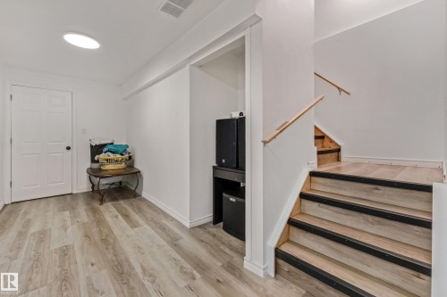 Light wood-finish flooring extending from the hallway to the staircase - 8131 Chappelle Way, Edmonton, AB - Indoor Photo Showing Other Room