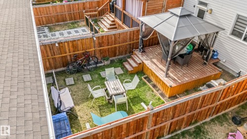 Private fenced backyard featuring a multi-level wooden deck with steps, a grass lawn, and a paved stone pathway - 8131 Chappelle Way, Edmonton, AB - Outdoor With Exterior