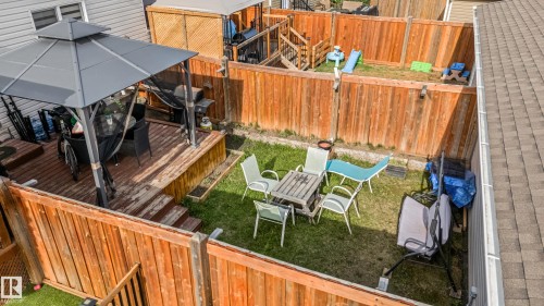 Expansive outdoor deck featuring a dark grey metal gazebo with netting, a built-in wooden planter box, and a privacy fence - 8131 Chappelle Way, Edmonton, AB - Outdoor With Exterior
