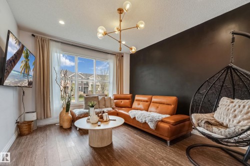 Living area featuring wood-finish flooring, a large multi-pane window, and recessed lighting - 8131 Chappelle Way, Edmonton, AB - Indoor Photo Showing Living Room