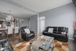 Open-concept living area featuring wood-finish flooring and light gray walls - 