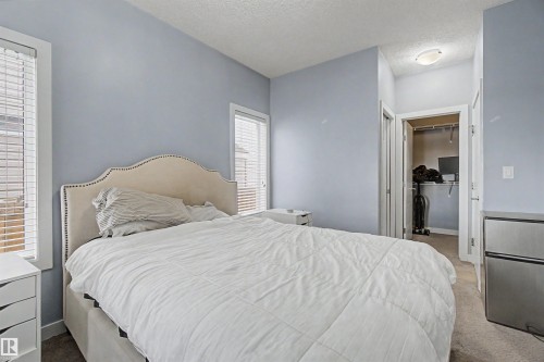Carpeted room with light blue walls and two windows featuring blinds - 1602 Chapman Way, Edmonton, AB - Indoor Photo Showing Bedroom