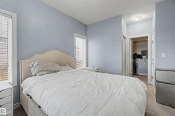 Carpeted room with light blue walls and two windows featuring blinds - 