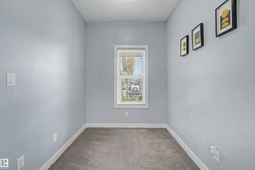 Carpeted room featuring light blue walls, white trim, and a window with blinds - 1602 Chapman Way, Edmonton, AB - Indoor Photo Showing Other Room