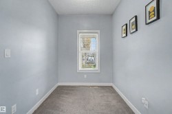 Carpeted room featuring light blue walls, white trim, and a window with blinds - 