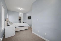 Carpeted room featuring a window with blinds, light blue wall paint, white trim, and a semi-flush ceiling light - 